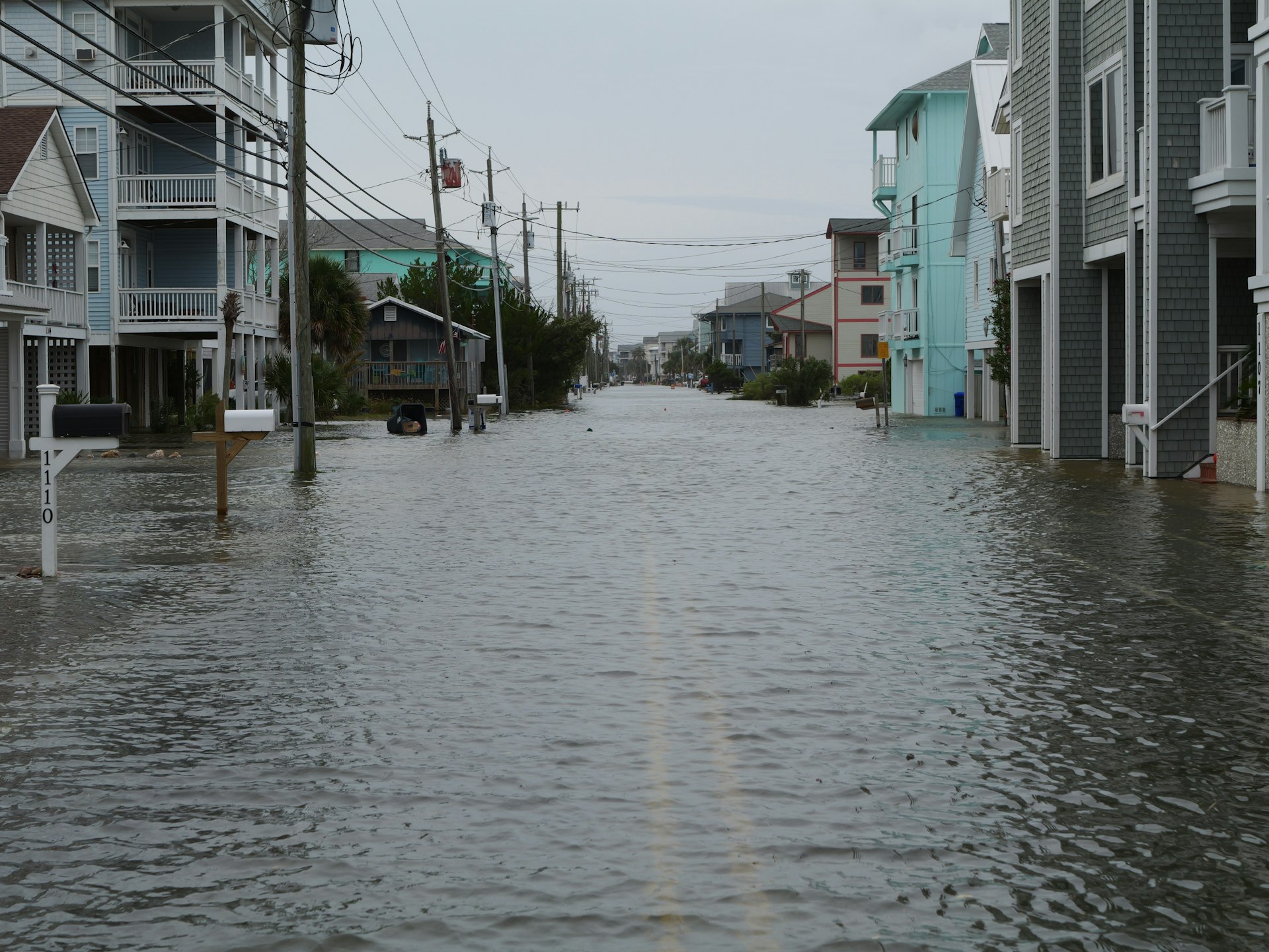 Floodwater covering a residential street between beach houses in Carolina Beach, North Carolina, during a king tide