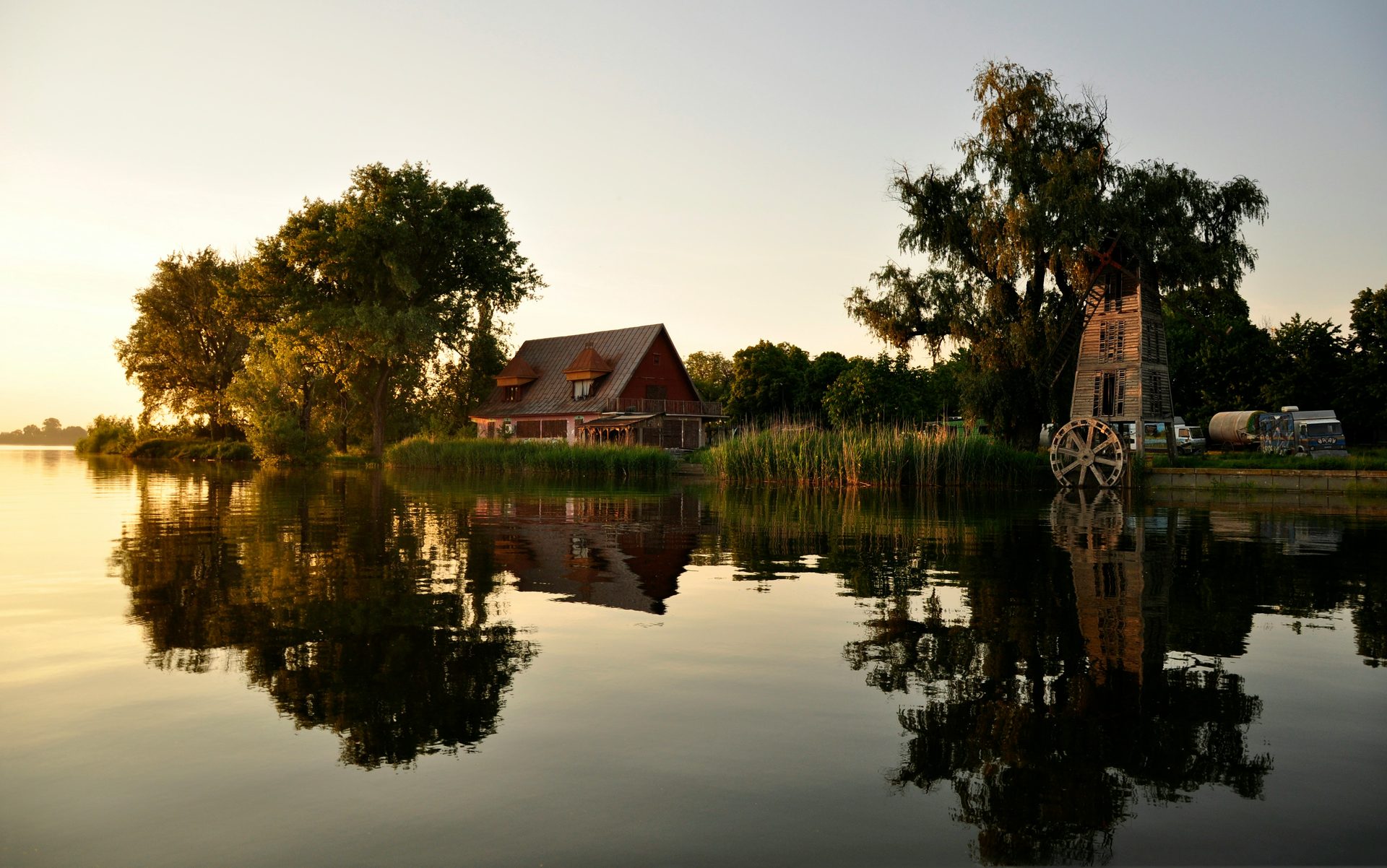 A house beside still water at golden hour, reflected in the lake