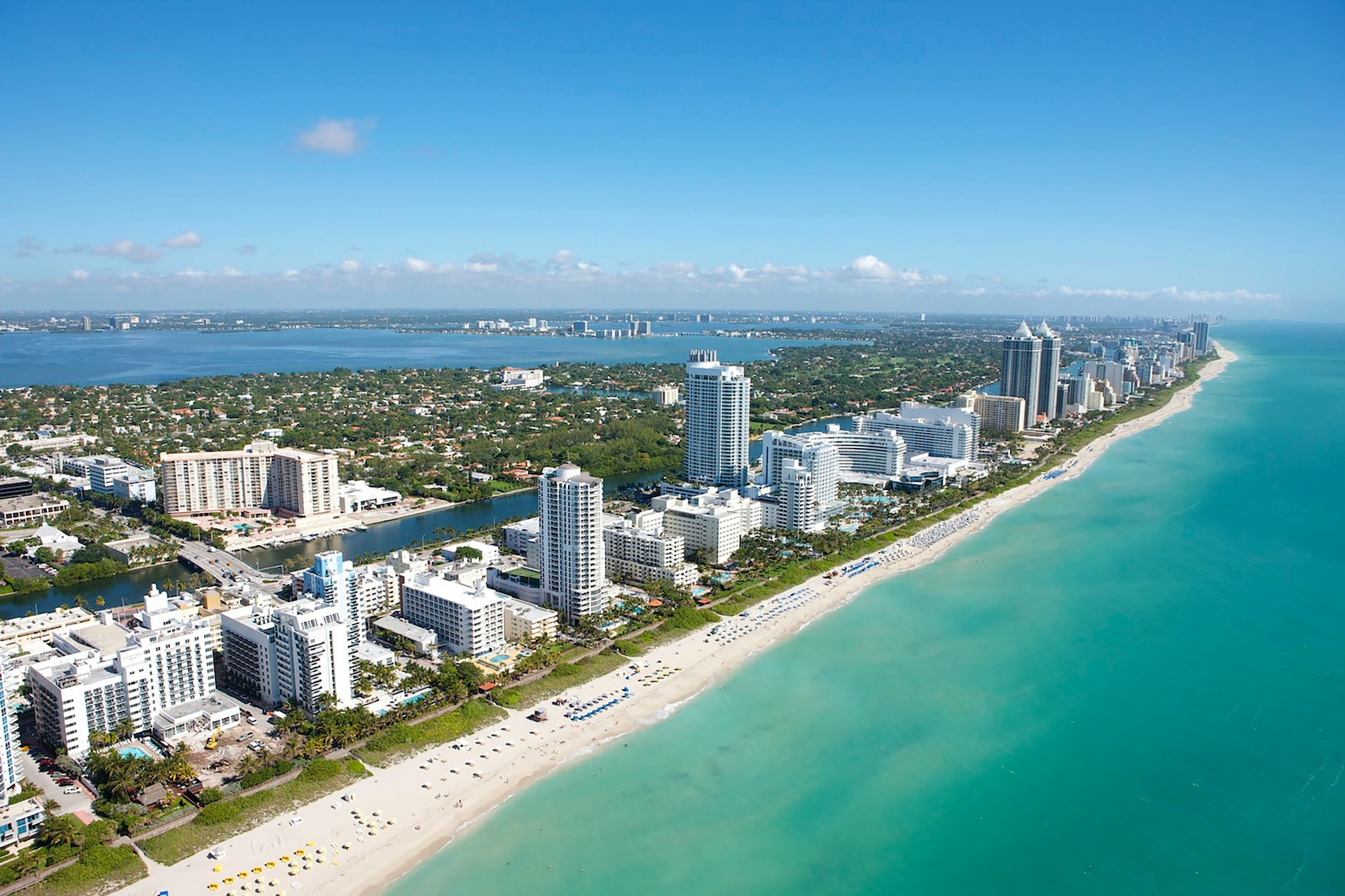 Aerial view of high-rise buildings lining the beachfront in Miami Beach, Florida
